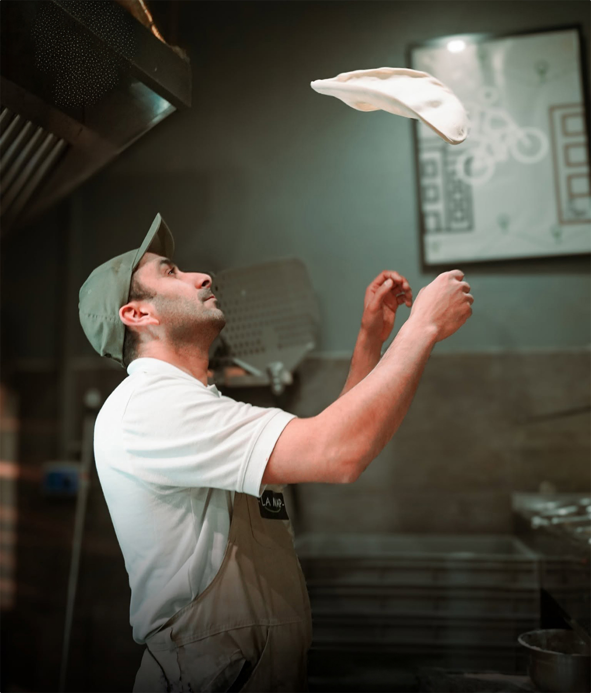 Photo d'un pizzaiolo faisant voler une pizza
